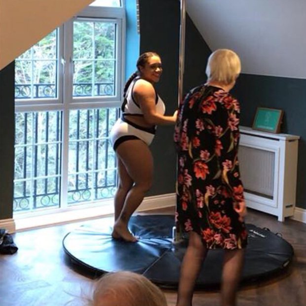 pole dancer showing elderly woman how to dance, racially diverse and age diverse